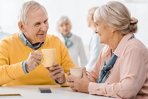 Elderly couple sitting in dining area having a cup of coffee